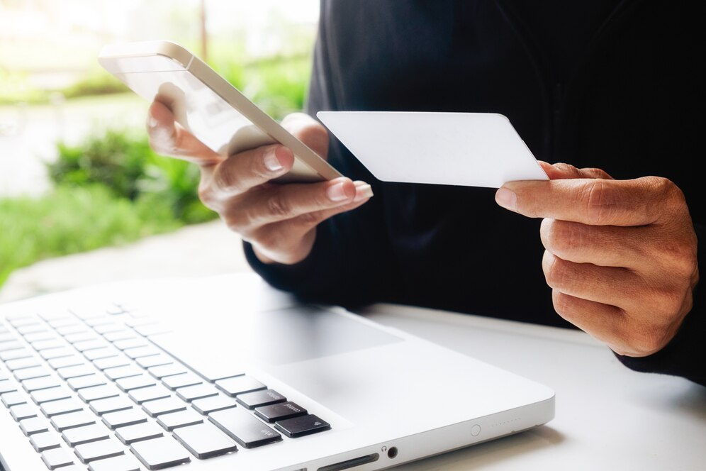 Man using phone and holding a card