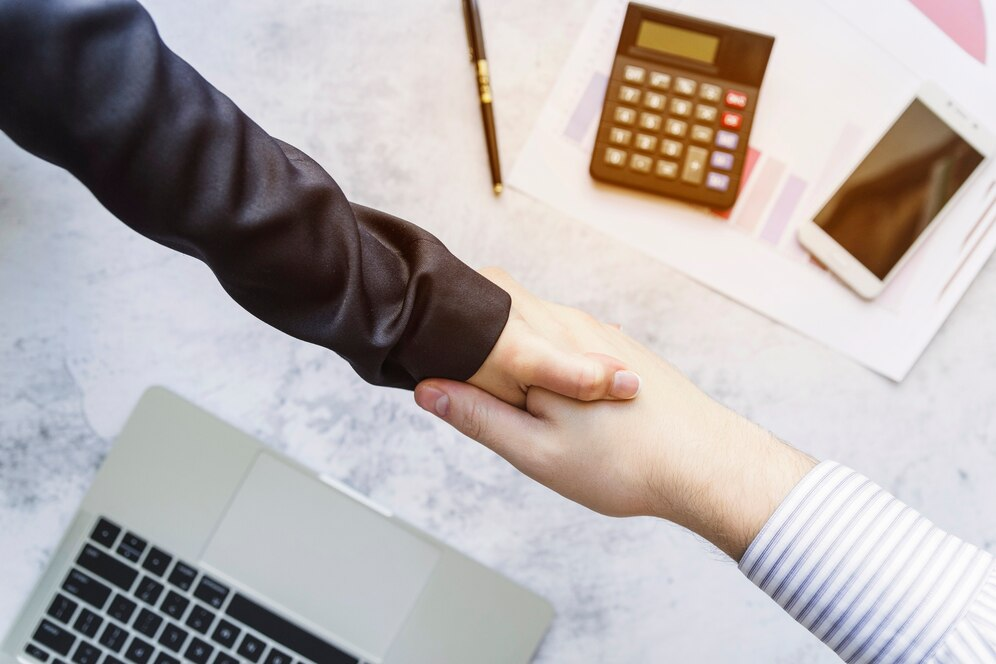 shaking hands above desk